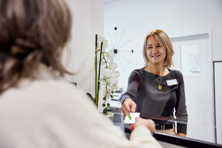 Frau reicht einer anderen Frau die Hand